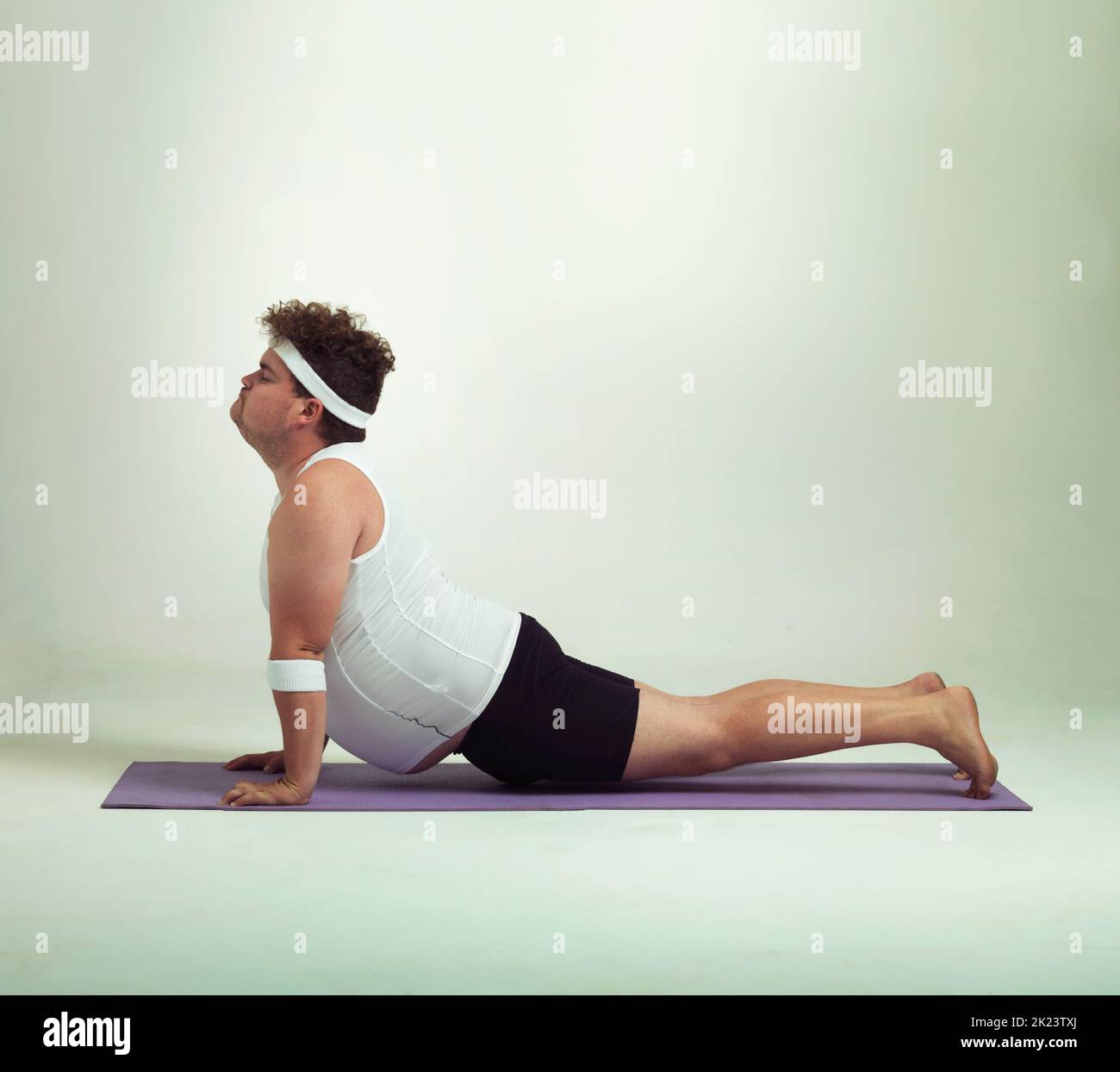 This upward facing dog pose is great. an overweight man doing yoga poses. Stock Photo