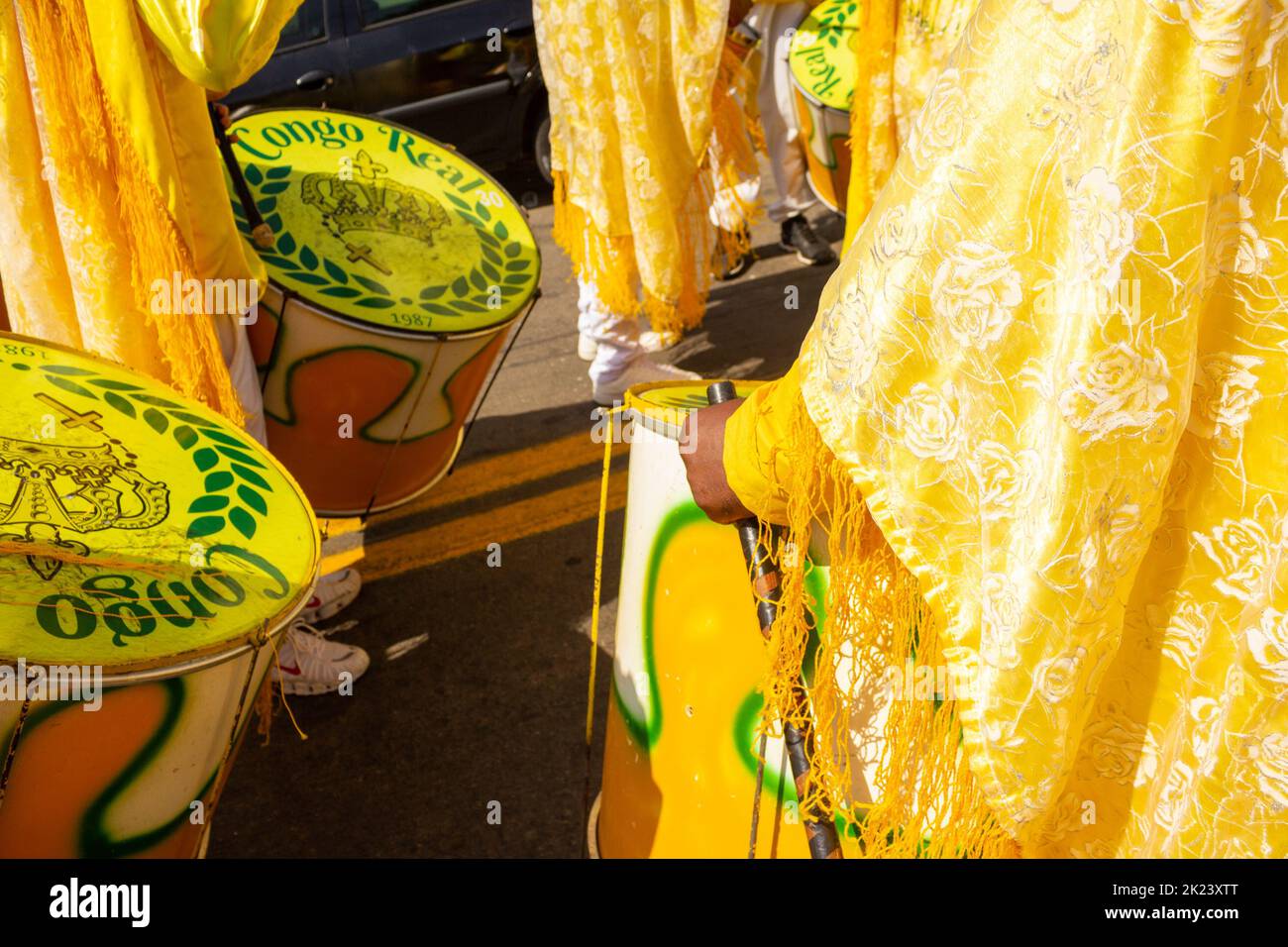 Goiânia, Goias, Brazil – September 11, 2022: Detail of some revelers using yellow drums during the Congadas. Stock Photo