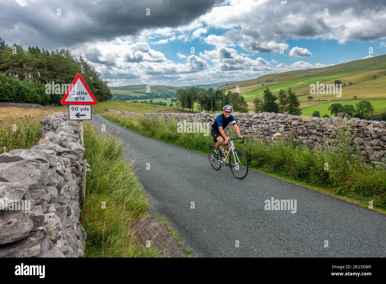 View down Littondale looking towards Wharfedale with a cyclist at one of the film locations for the new All Creatures Great And Small series, Kilnsey Stock Photo