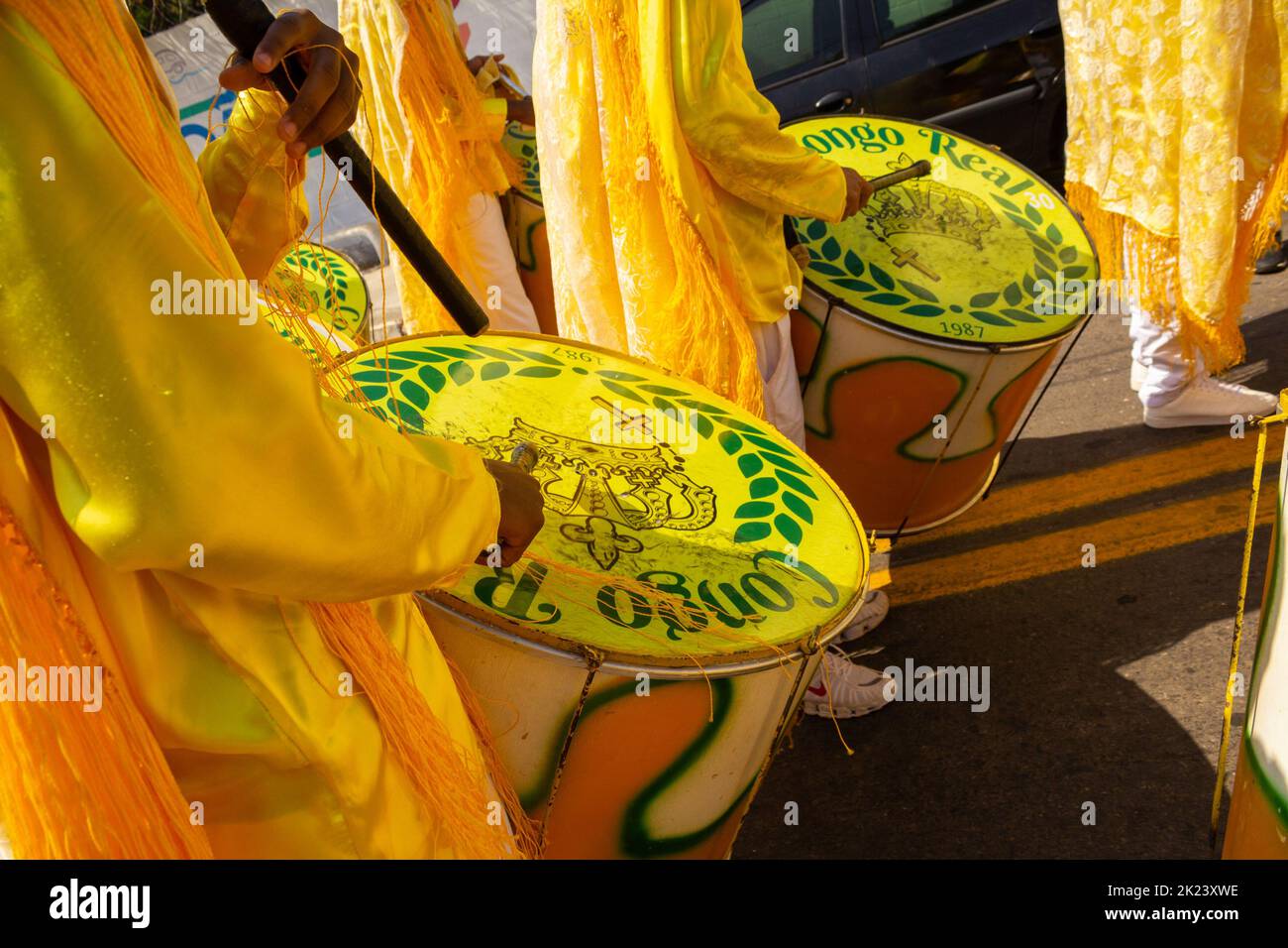 Goiânia, Goias, Brazil – September 11, 2022: Detail of some revelers using yellow drums during the Congadas. Stock Photo