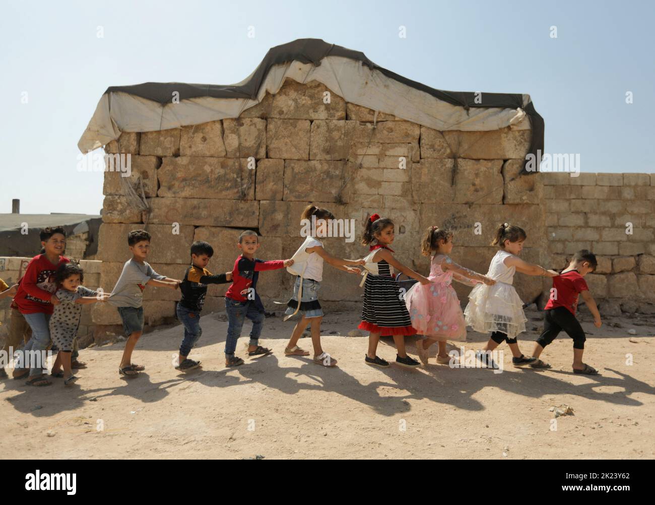 Internally displaced children walk together in the opposition-held Idlib, Syria September 20, 2022. REUTERS/Khalil Ashawi Stock Photo