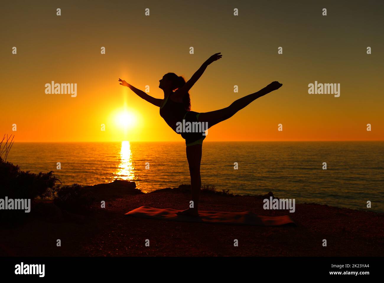 Backlight ballerina silhouette danding ballet at sunset on the beach Stock Photo