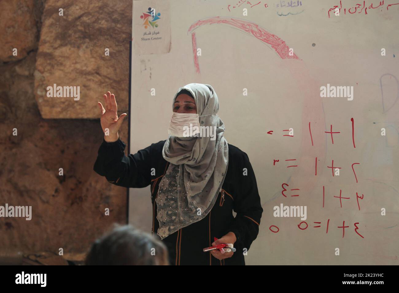 Najlaa Mimar, a history graduate who has transformed a Byzantine castle into a makeshift school for the internally displaced children, gestures inside a classroom, in the opposition-held Idlib, Syria September 20, 2022. REUTERS/Khalil Ashawi Stock Photo