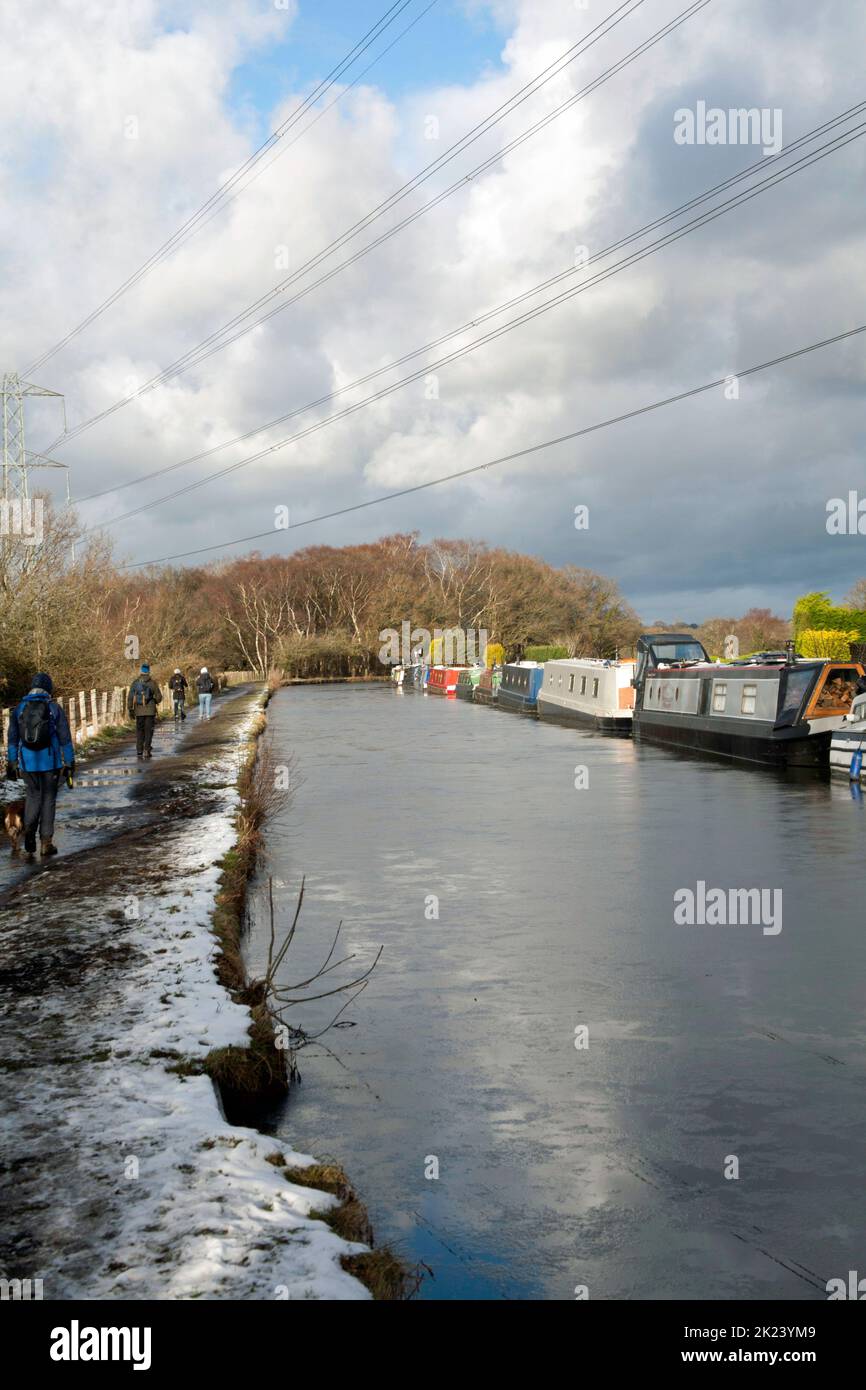 Narrow boats moored along the frozen Macclesfield Canal on a cold winter day at Higher Poynton Cheshire England Stock Photo