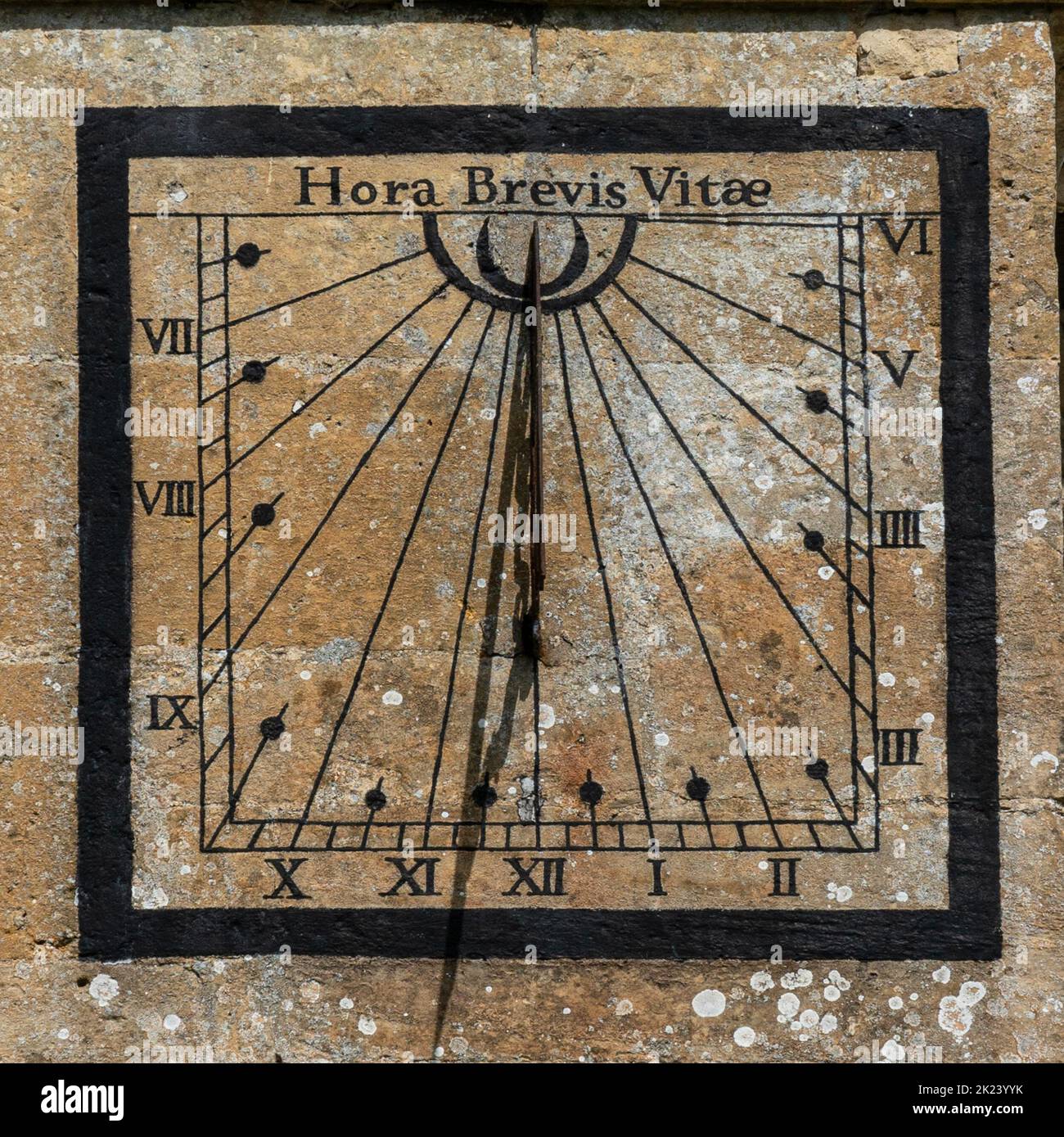 Sundial on the church of St Andrew in the Cotswold village of Chedworth, Gloucestershire, United Kingdom. Hora Brevis Vitae WHICH TRANSLATES AS -  An Stock Photo