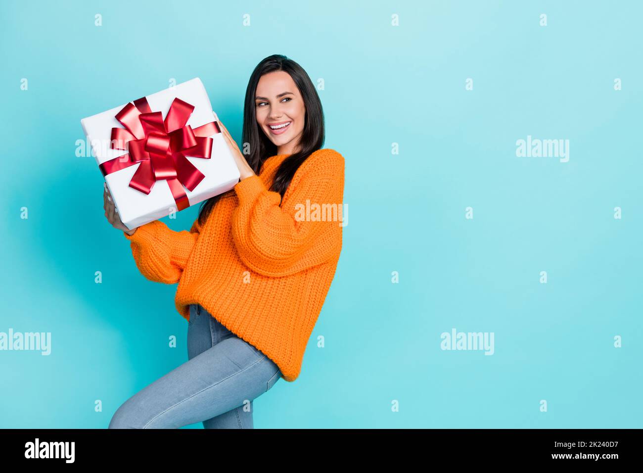 Portrait of gorgeous cheerful person hands hold giftbox look empty space isolated on teal color background Stock Photo