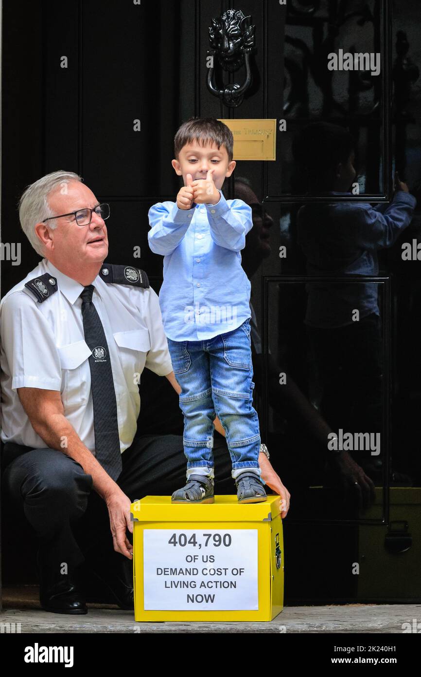 London, UK. 22nd Sep, 2022. Kingsley hands the Downing Street security officer the petition. Brighton mum Merve Kalgidim, and her 3-year old son Kingsley, hand in the petition and box with collected signatures a day ahead of Friday's 'mini budget'. Families, charities and faith leaders who together have collected signatures for a 38 Degrees petition, hand in that petition at 10 Downing Street today to demand an emergency budget to help people with the Cost of Living Crisis. Credit: Imageplotter/Alamy Live News Stock Photo