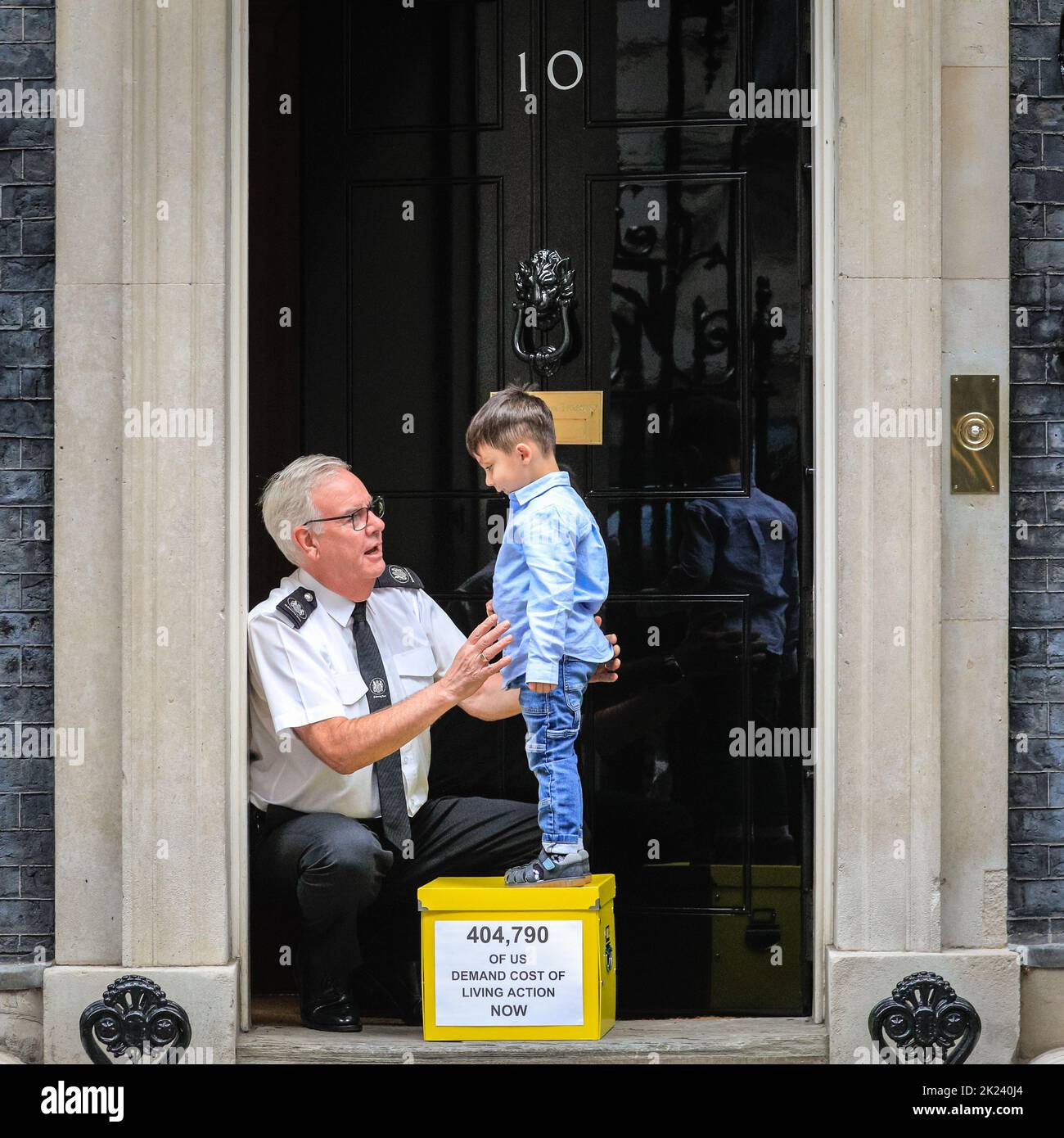 London, UK. 22nd Sep, 2022. Kingsley hands the Downing Street security officer the petition. Brighton mum Merve Kalgidim, and her 3-year old son Kingsley, hand in the petition and box with collected signatures a day ahead of Friday's 'mini budget'. Families, charities and faith leaders who together have collected signatures for a 38 Degrees petition, hand in that petition at 10 Downing Street today to demand an emergency budget to help people with the Cost of Living Crisis. Credit: Imageplotter/Alamy Live News Stock Photo