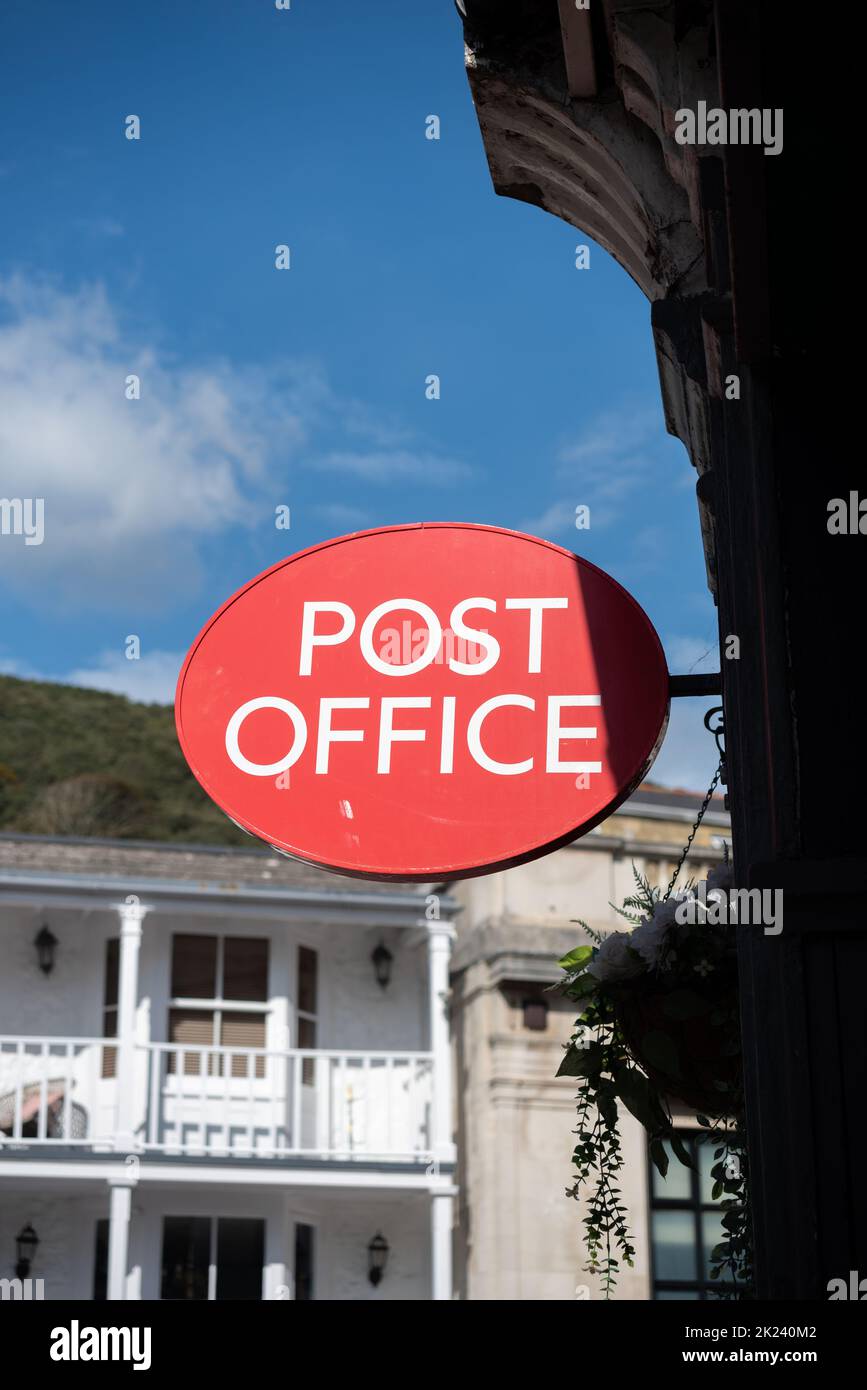 Bright red Post office sign outside a building in England, common sight in most high streets. Stock Photo
