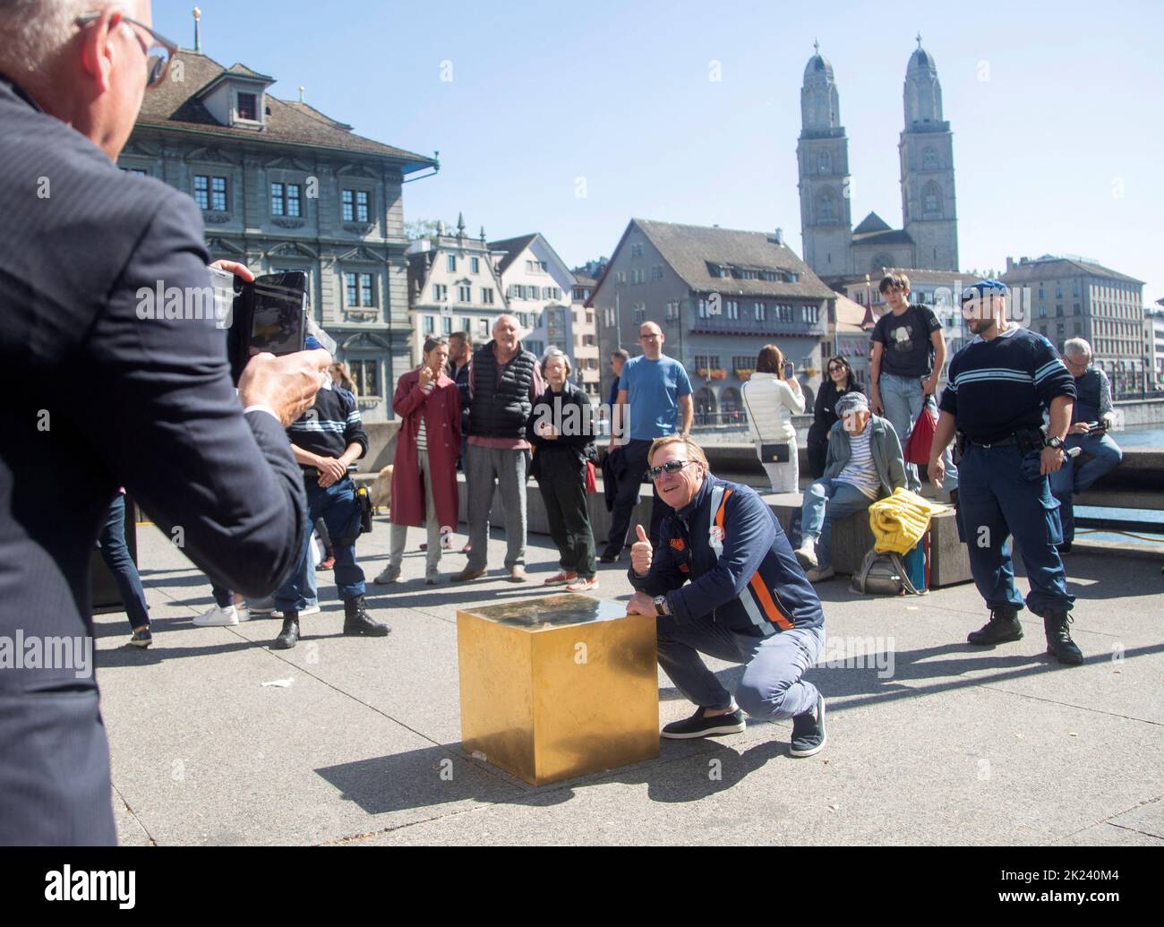A man poses for a picture behind artist Niclas Castello's work 'The Castello CUBE' , made of 186 kg, 24-carat, 999.9 fine gold, during a presentation on the Rathausbruecke bridge in Zurich, Switzerland September 22, 2022.  REUTERS/Arnd Wiegmann Stock Photo