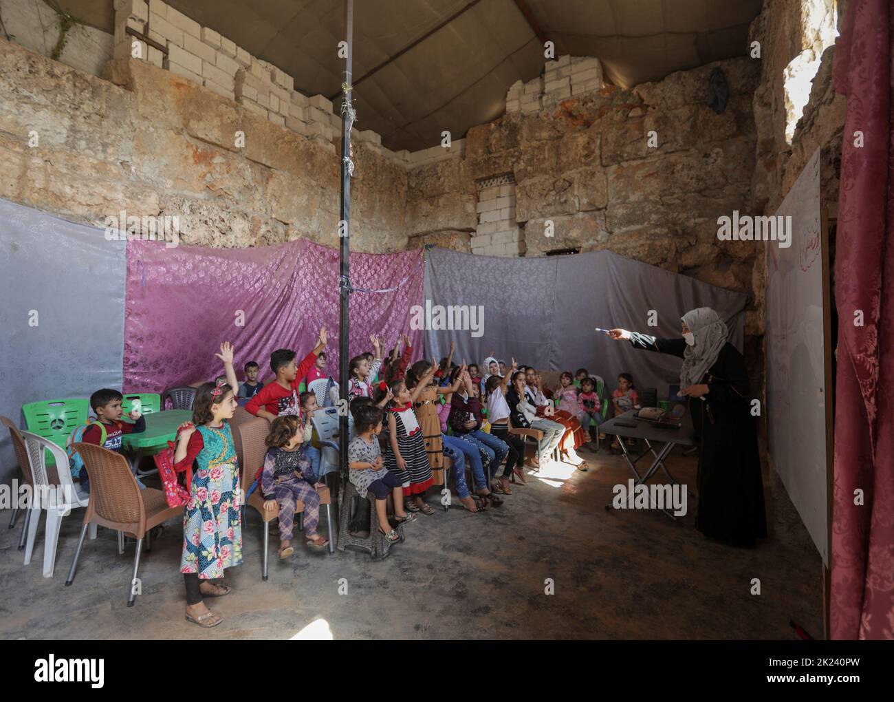 Students attend a class inside a Byzantine castle that was transformed into a makeshift school for the internally displaced children, in the opposition-held Idlib, Syria September 20, 2022. REUTERS/Khalil Ashawi Stock Photo