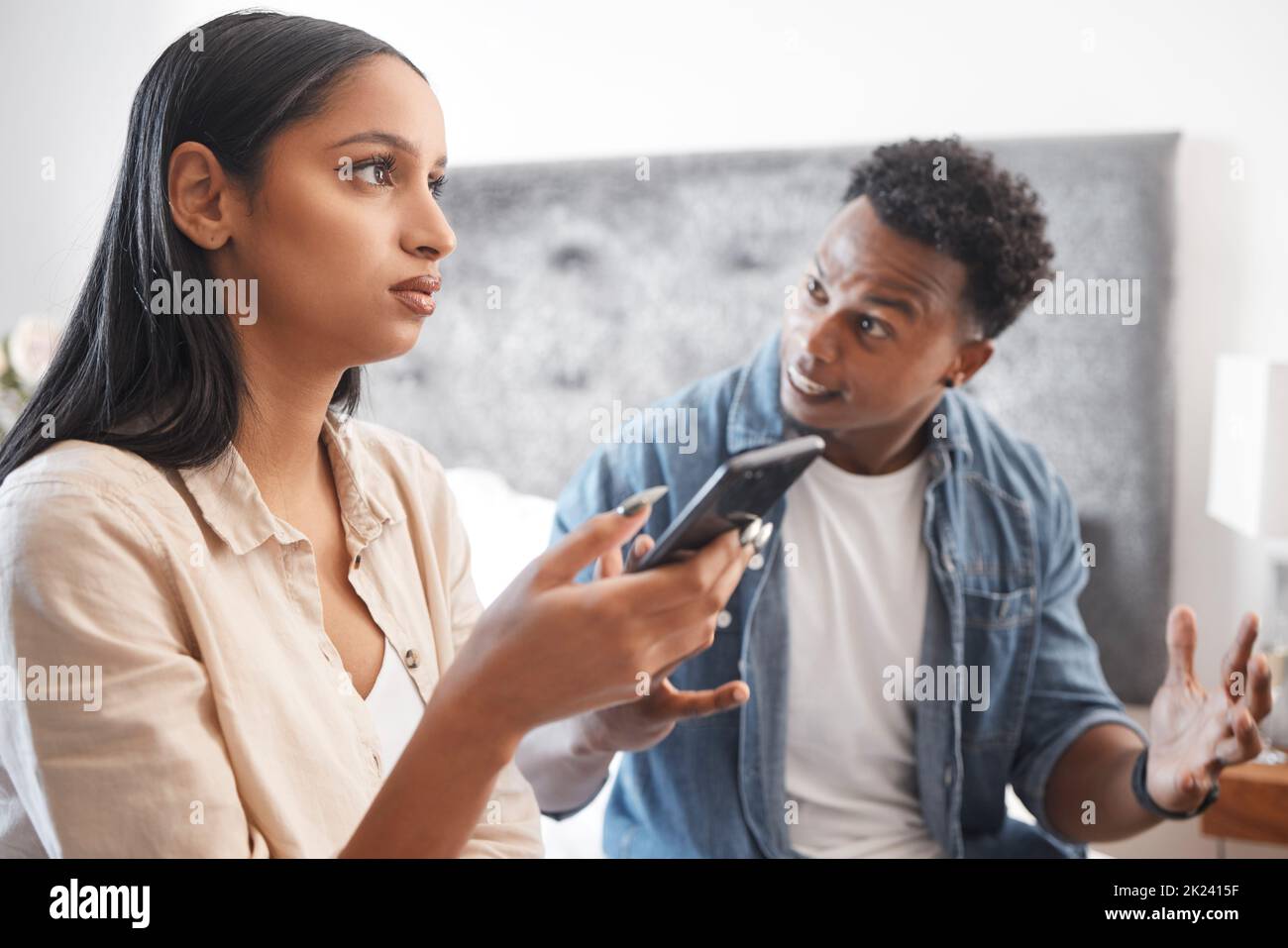 Couple fight for phone social media text or cheating crisis message in bedroom at house or home