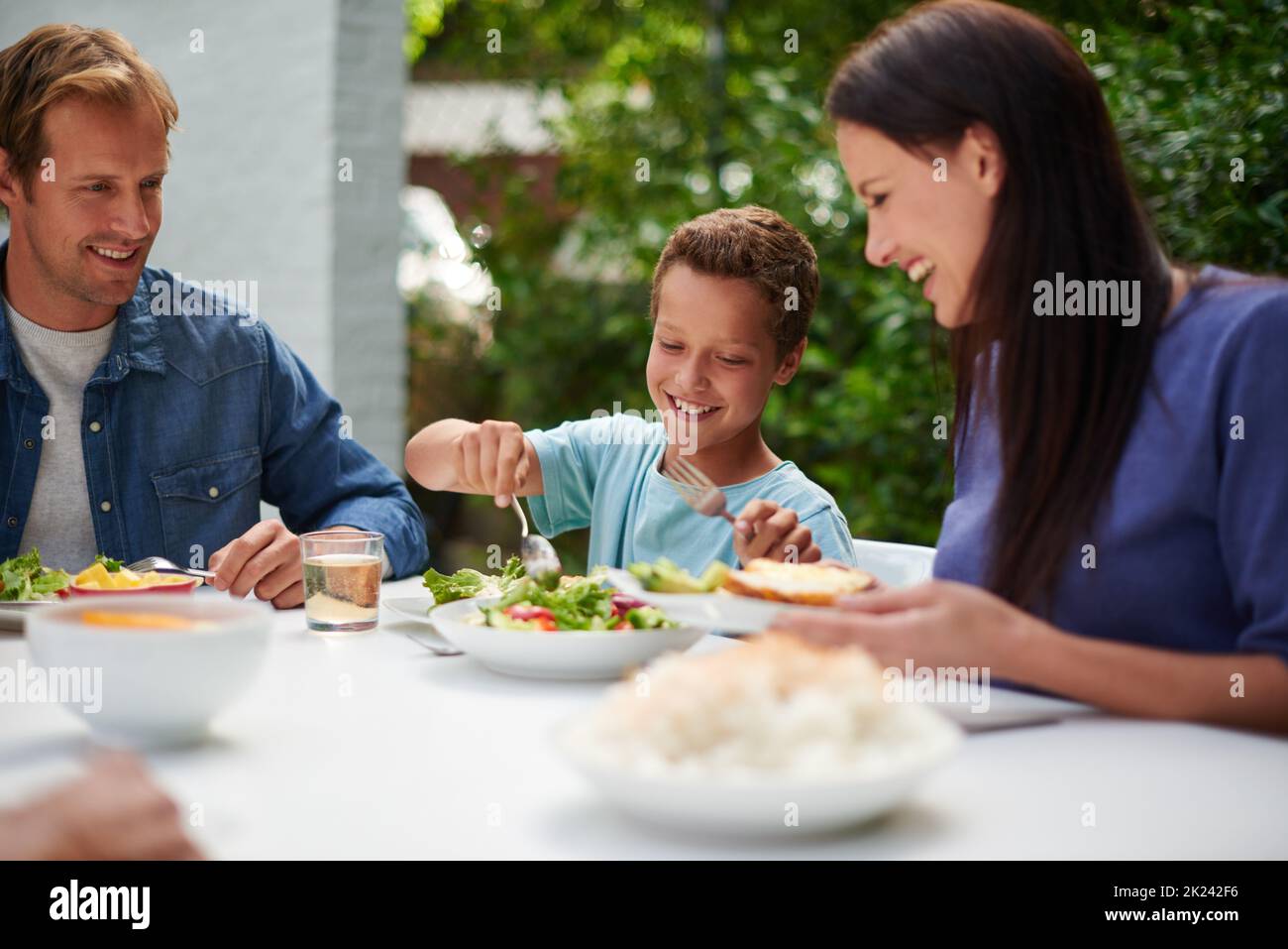 Enjoying a hearty family meal. a family enjoying a meal outside. Stock Photo