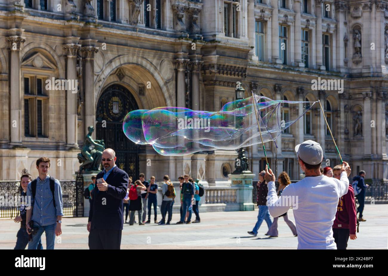 A picture of a street artist making a giant bubble in a square Stock