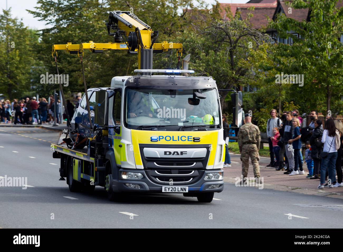 Police tow away vehicle truck removes and illegally parked car at a large event in London. The numberplate of the vehicle has been digitally altered and does not show the real registration. (132) Stock Photo