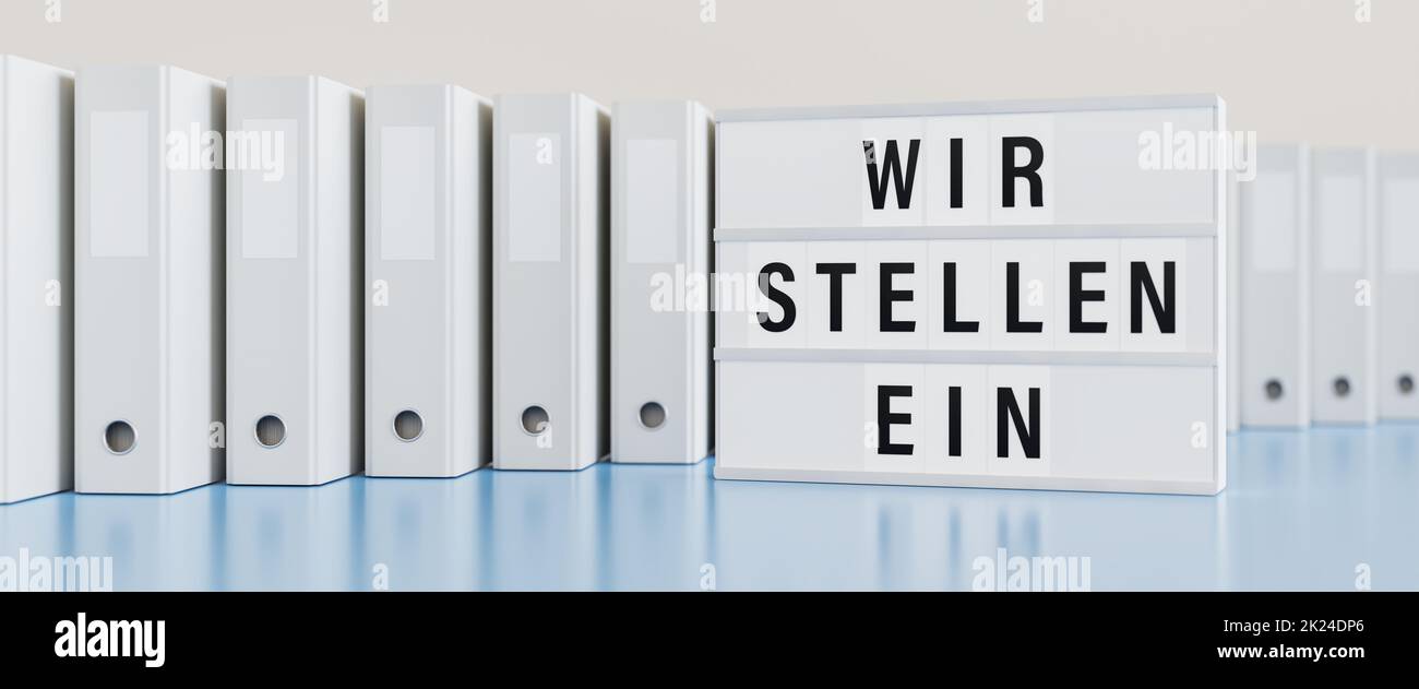 Lightbox displaying the German text 'Wir stellen ein' (wir stellen ein) with office binders behind. Stock Photo