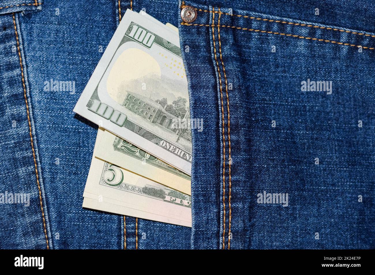 Dollars stick out of the pocket of jeans. Money in your pocket. Stock Photo
