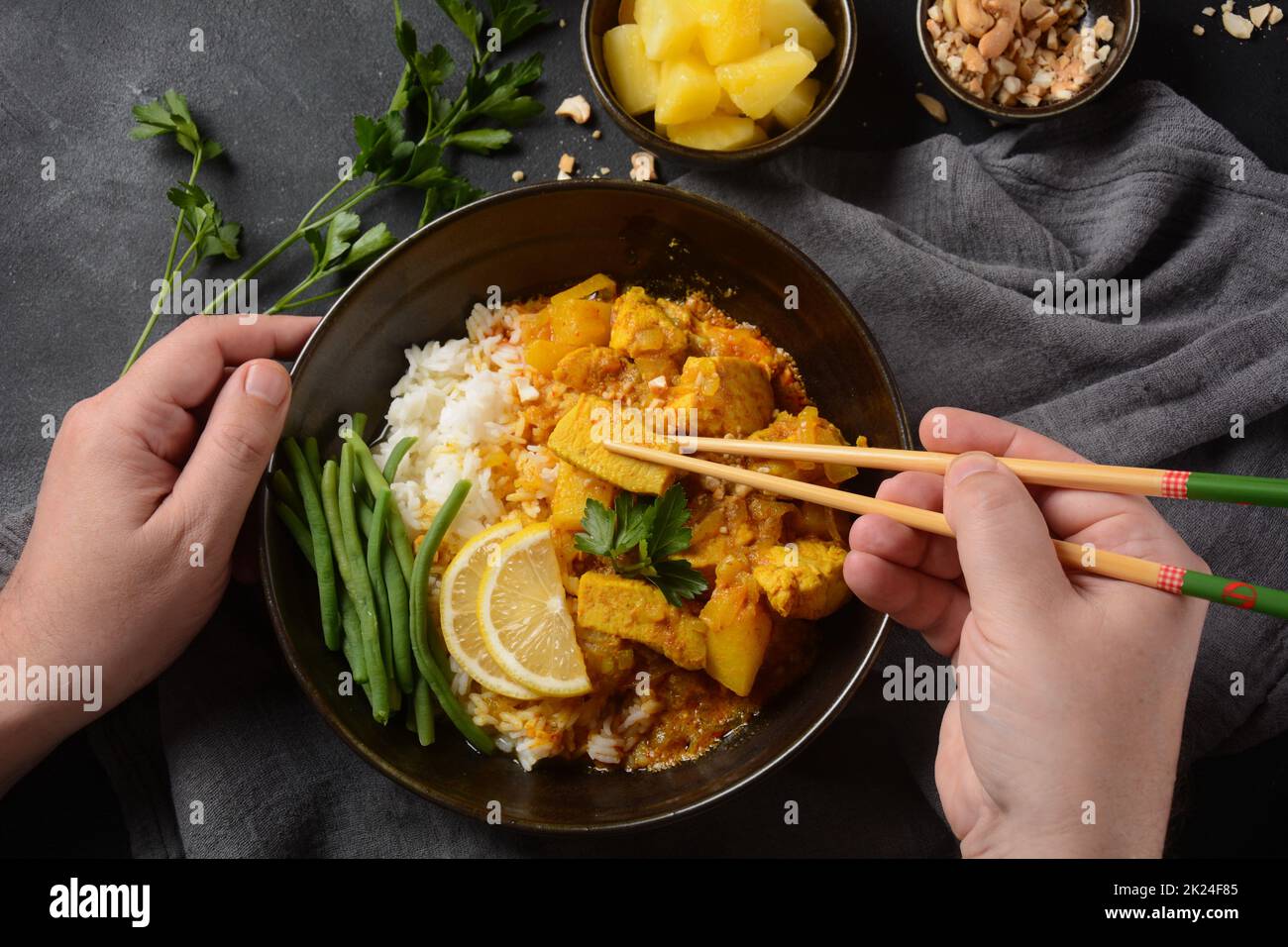 A Chicken Massaman Curry in black bowl at dark background. Massaman Curry is Thai Indian best dish with chicken meat, potato, onion and many spices is Stock Photo