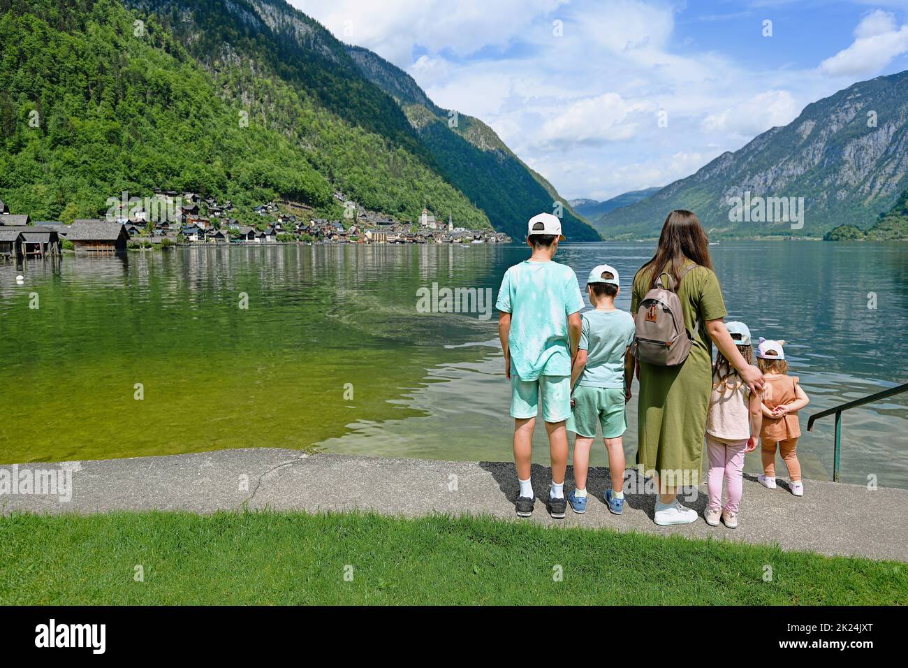 Back of mother with four children over Austrian alps lake in Hallstatt, Salzkammergut, Austria. Stock Photo