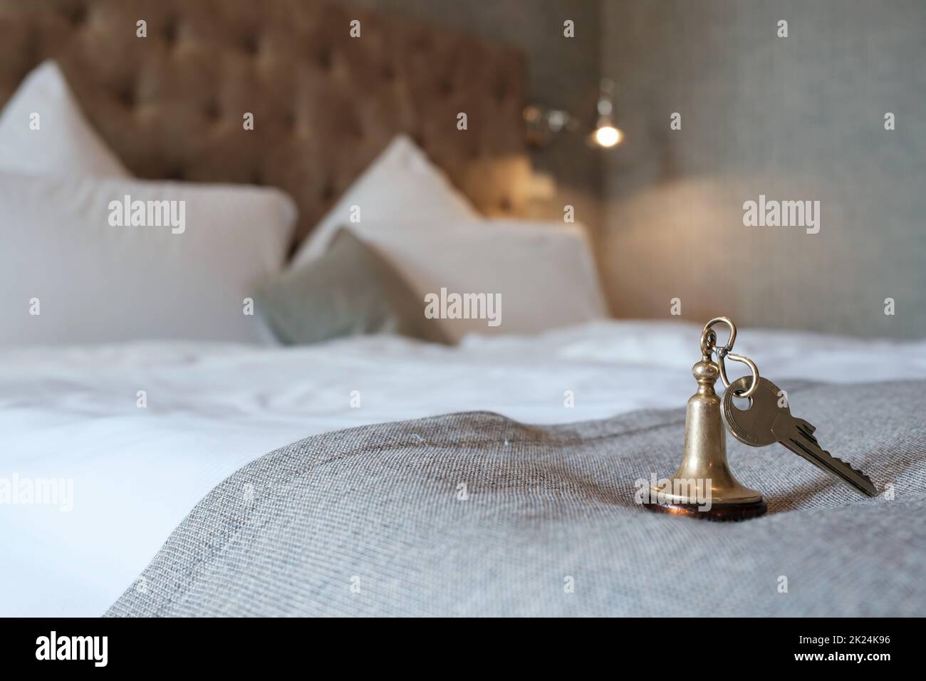 Key with a key fob from the hotel room lies on the bed. Stock Photo