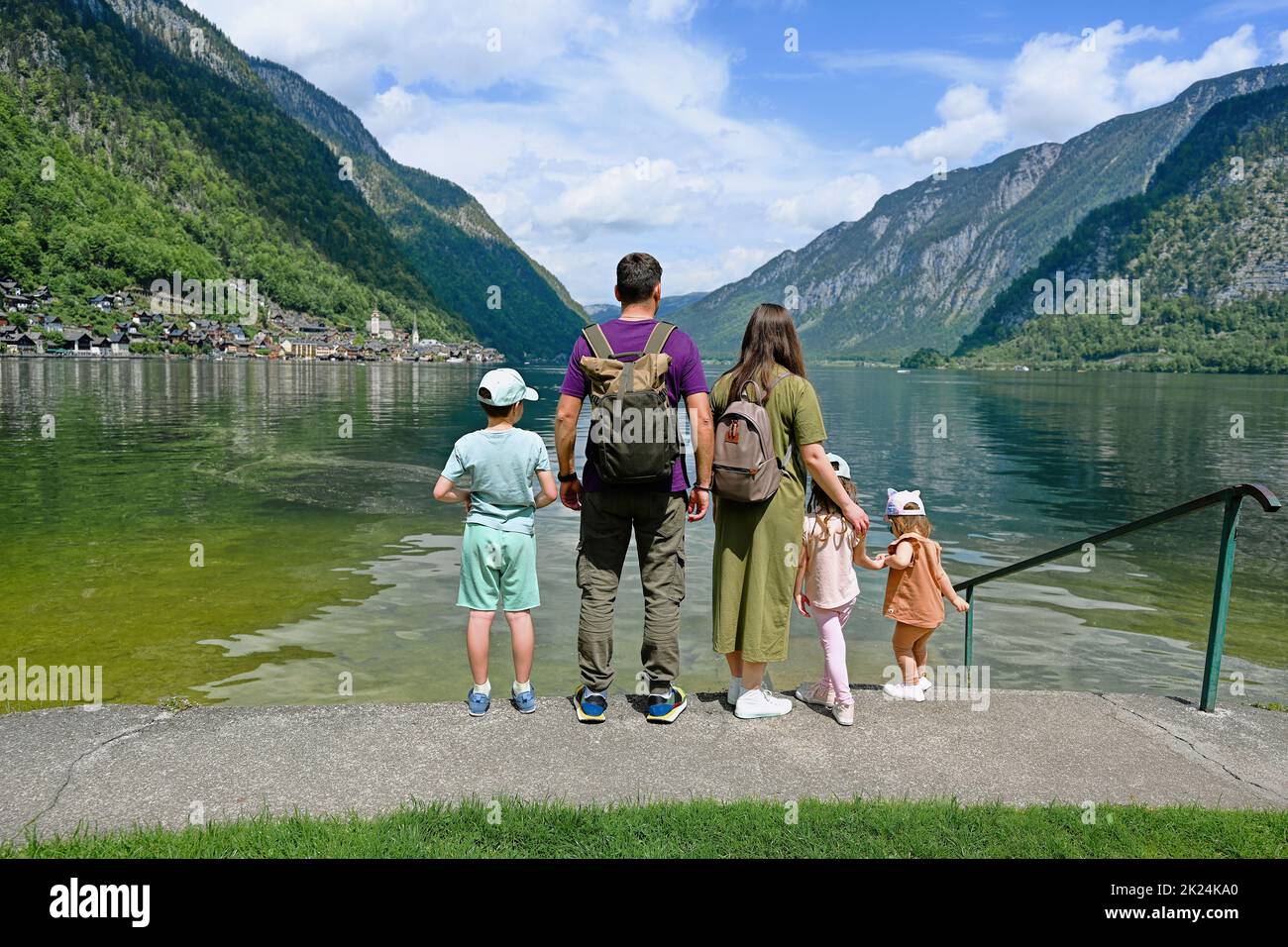 Back of family with three children over Austrian alps lake in Hallstatt, Salzkammergut, Austria. Stock Photo