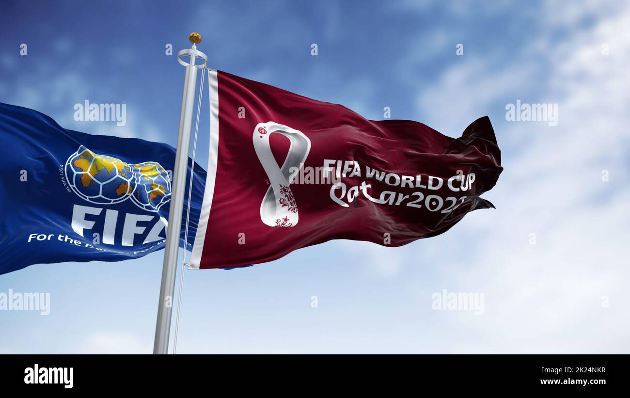 Doha, Qatar, January 2022: Flags with FIFA and Qatar 2022 World Cup logo waving in the wind. The event is scheduled in Qatar from 21 November to 18 De Stock Photo