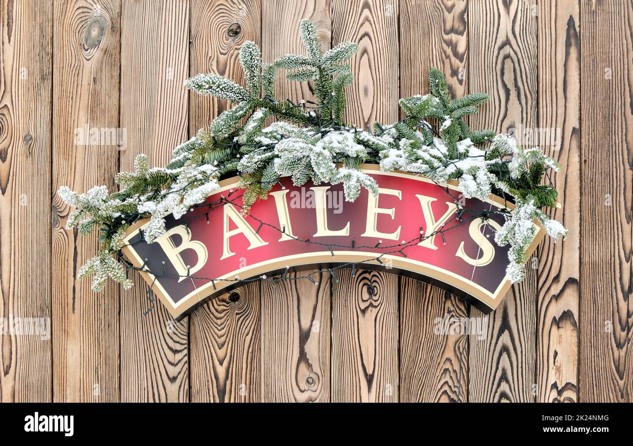 Baileys Irish Cream Christmas decoration on wooden wall in winter, alcoholic drink brand closeup Stock Photo