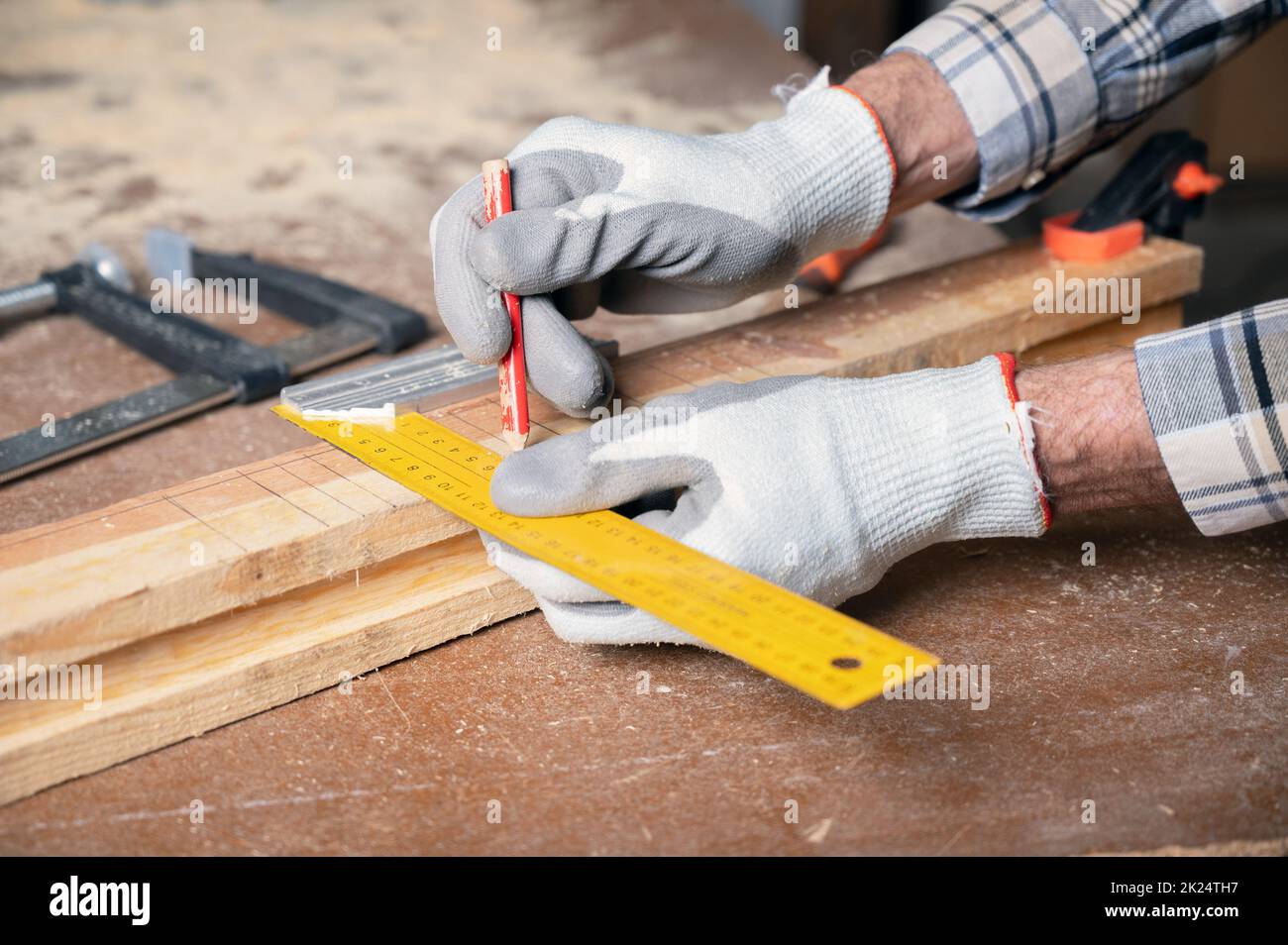 Woodwork and furniture making concept. Carpenter in the workshop marks ...