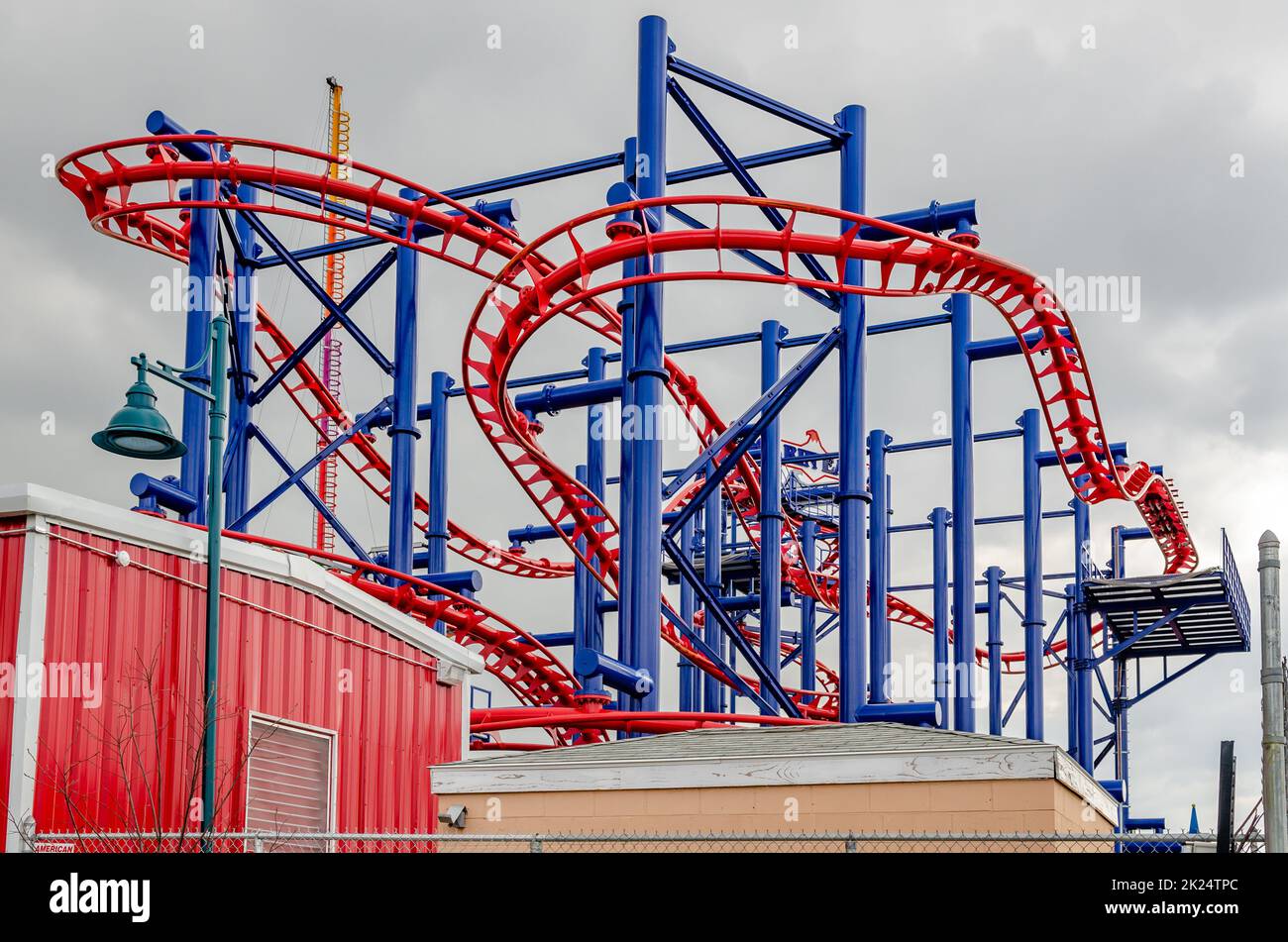 Soarin' Eagle Rollercoaster at Coney island, Brooklyn, New York City during winter day with cloudy sky, view from low angle, buildings in front, horiz Stock Photo