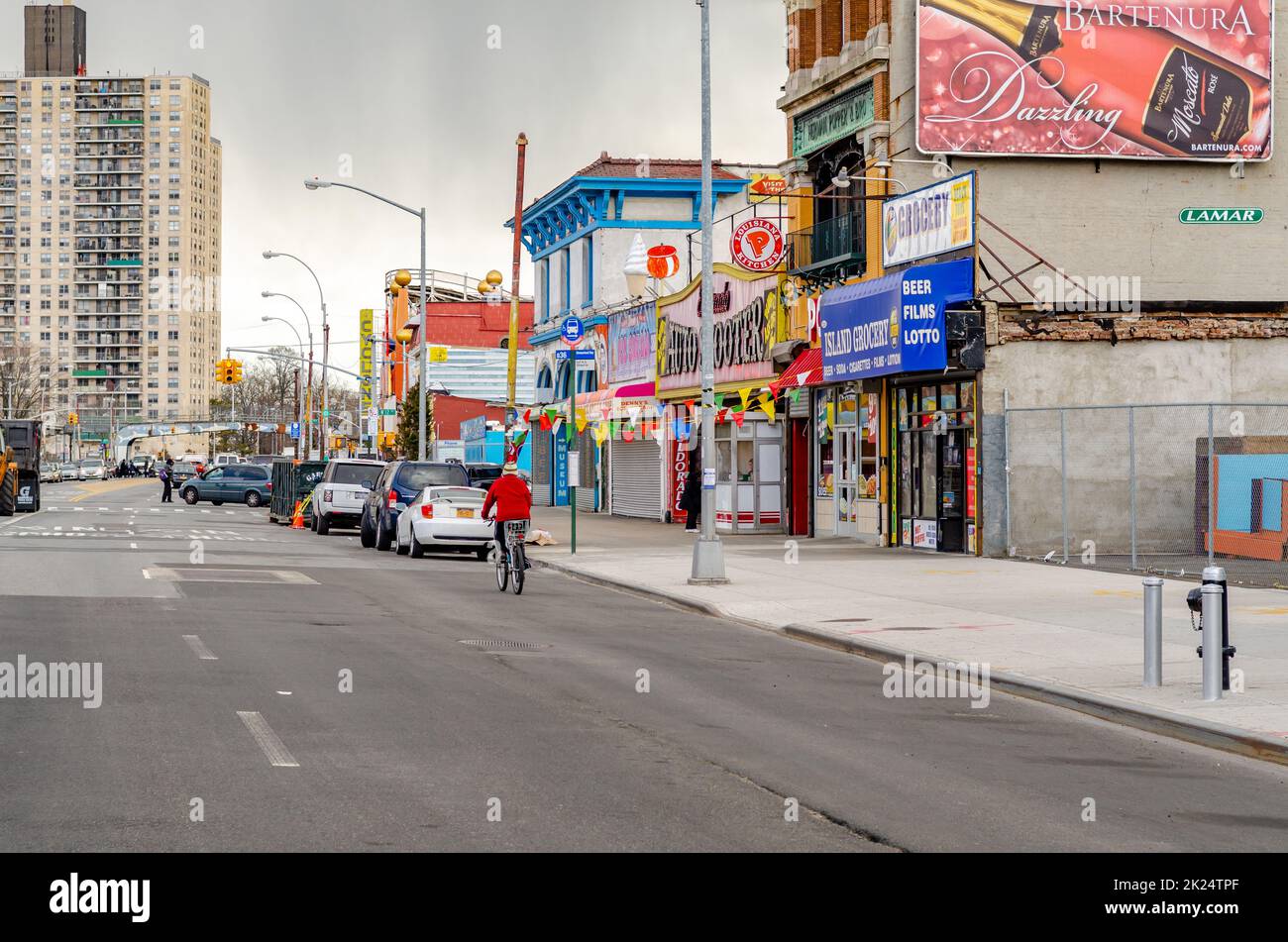 Stores and Restaurants at City Street in Coney island, Brooklyn, New York City during winter day with cloudy sky, Cars parked next to the street in fr Stock Photo