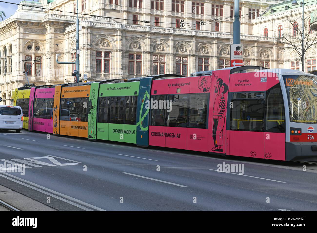 Bunte Straßenbahn in Wien mit mehrsprachiger Aufschrift zu Coronafragen, Österreich - Colorful tram in Vienna with multilingual inscription on corona Stock Photo