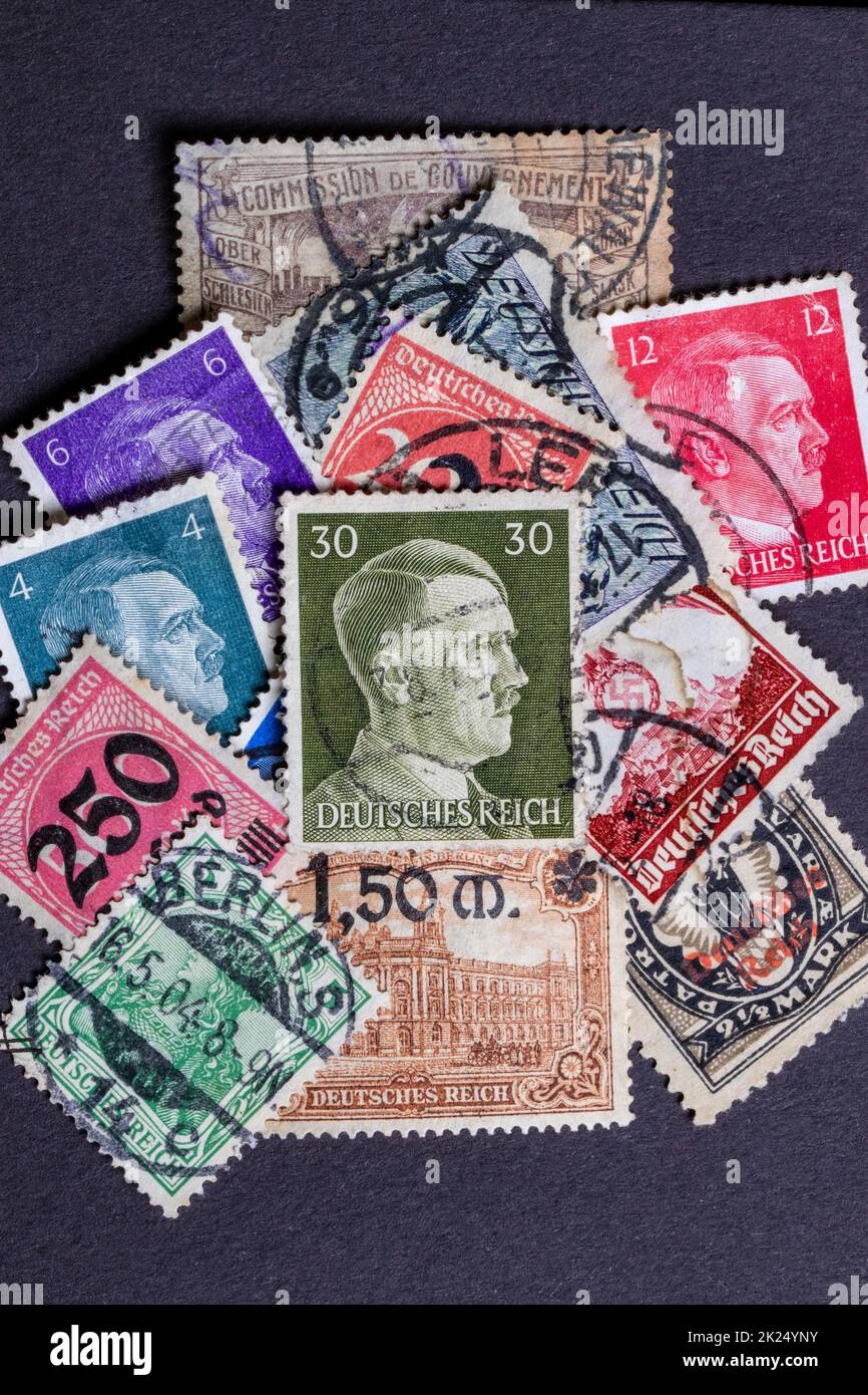 Potsdam, Germany - APR 26, 2022. A stack of old German stamps from the Third Reich and on it a stamp with printed portrait of Adolf Hitler, the leader Stock Photo
