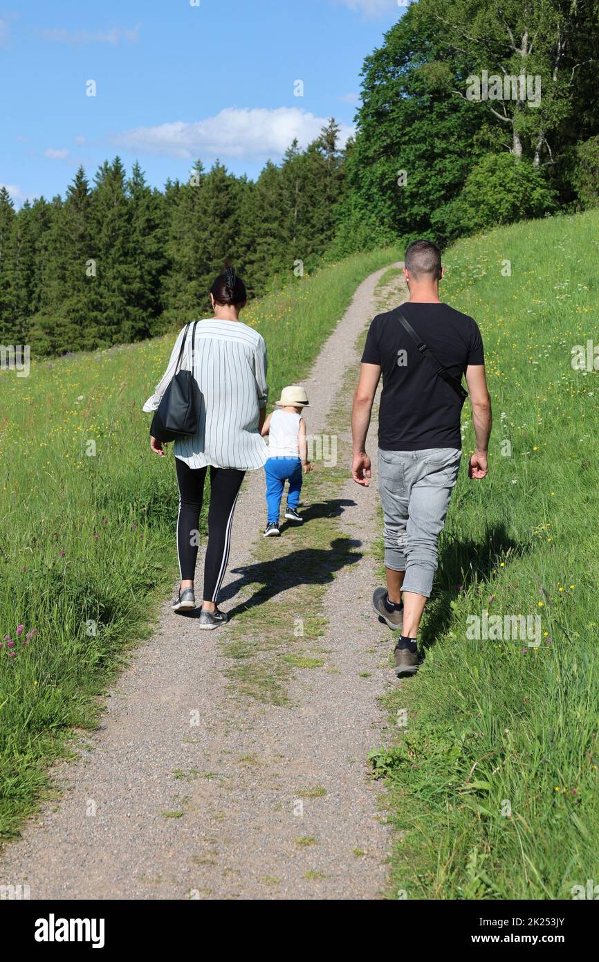 Eine junge Familie mit Kind genießt bei einem Spaziergang bei Hinterzarten (Landkreis Breisgau-Hochschwarzwald) die Schönheit der Natur und Schwarzwal Stock Photo