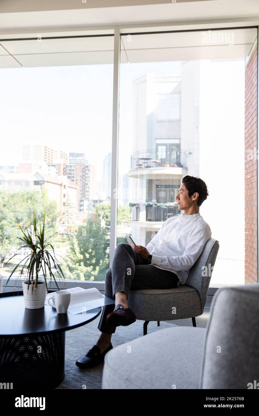 Man relaxing on armchair in breakout area Stock Photo Alamy