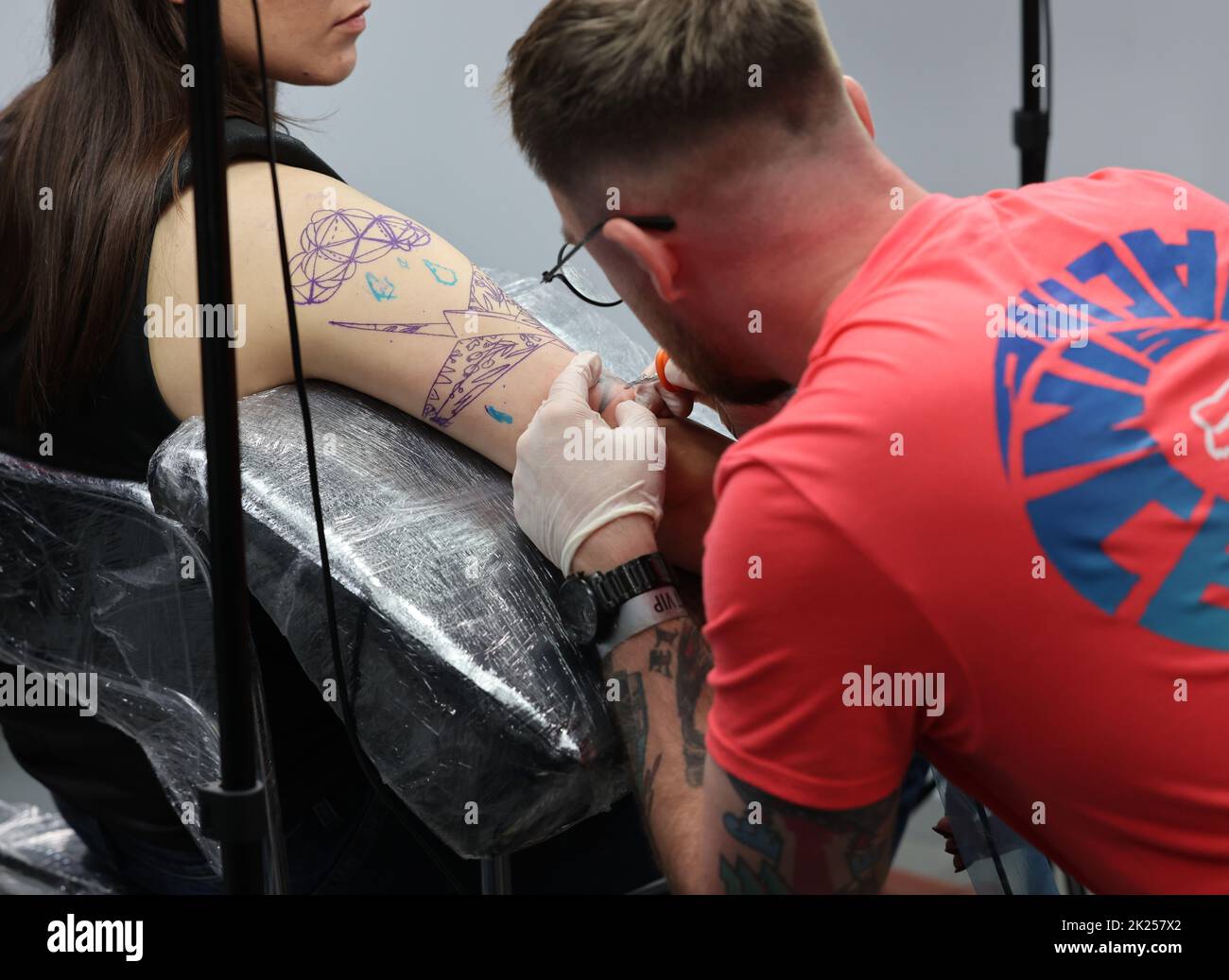Krakow, Poland -  June 11, 2022: 15th Tattoofest in Cracow. One of the most prestigious tattoo festivals. Tattoo artist at work. The process of tattoo Stock Photo