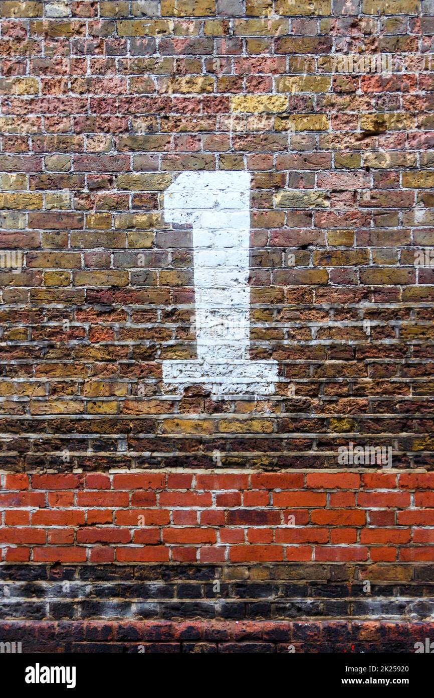 The number one painted in white on a distressed brick wall Stock Photo