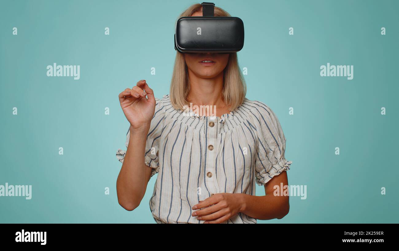 Exited stylish woman using virtual reality futuristic technology VR app ...