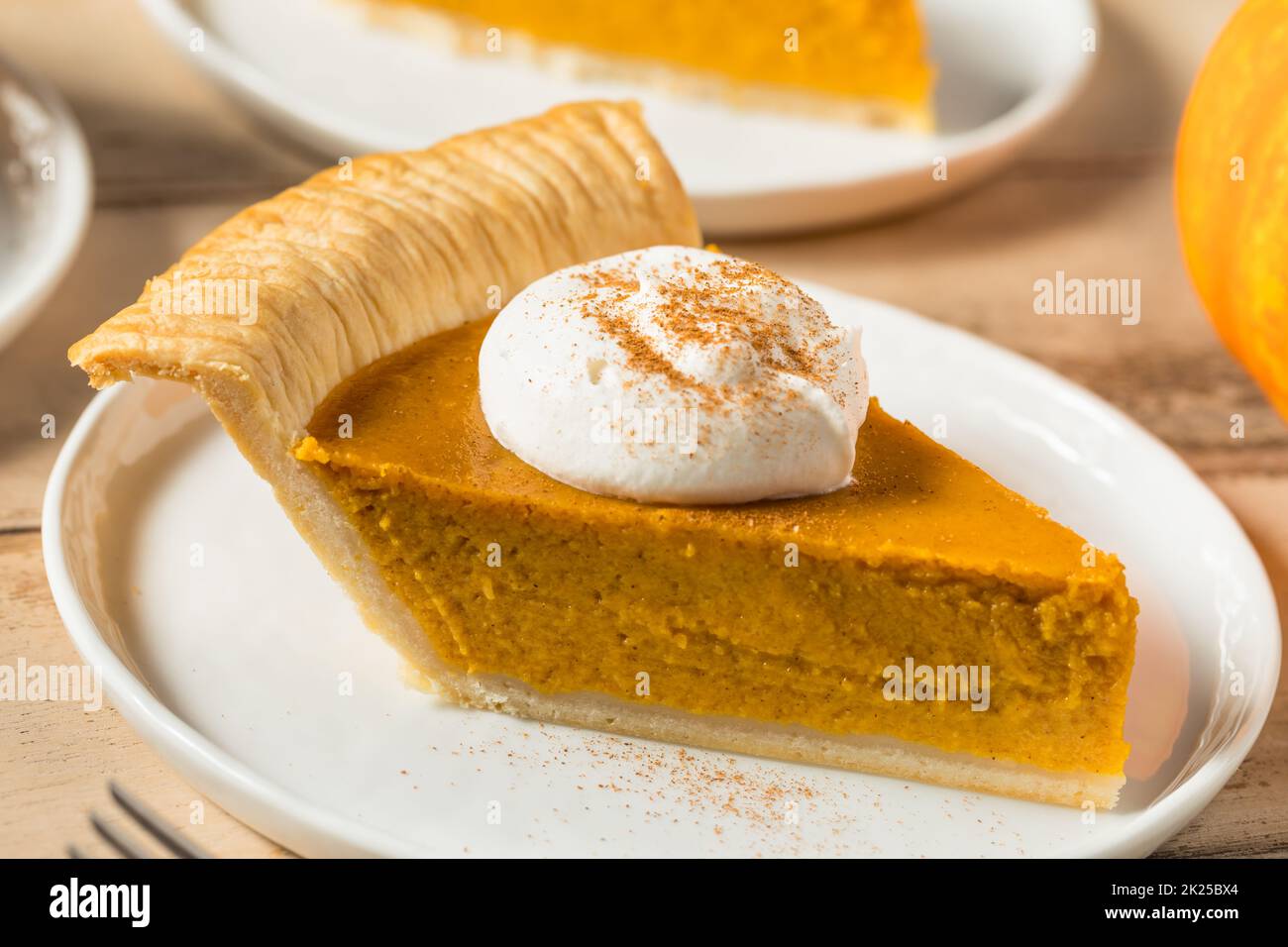 Homemade Thanksgiving Pumpkin Pie with Whipped Cream and Spice Stock Photo