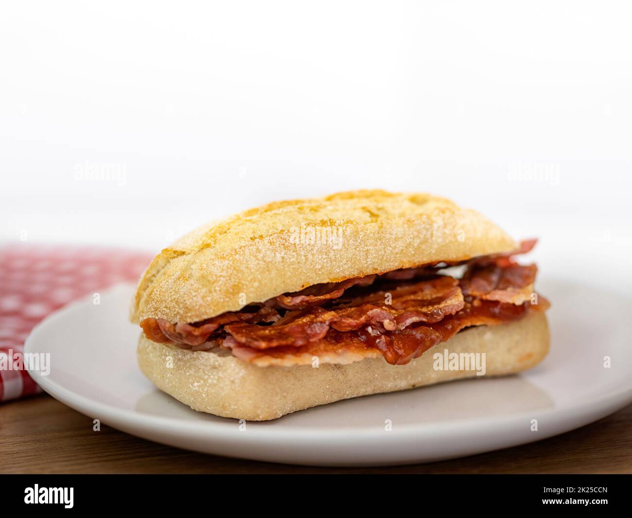 Closeup of crispy bacon in a sourdough roll Stock Photo
