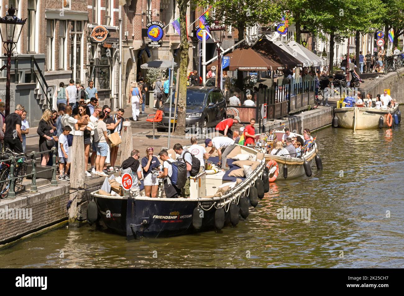 Amsterdam, Netherlands - August 2022: Tourists getting on a sightseeing canal boat in the city centre Stock Photo