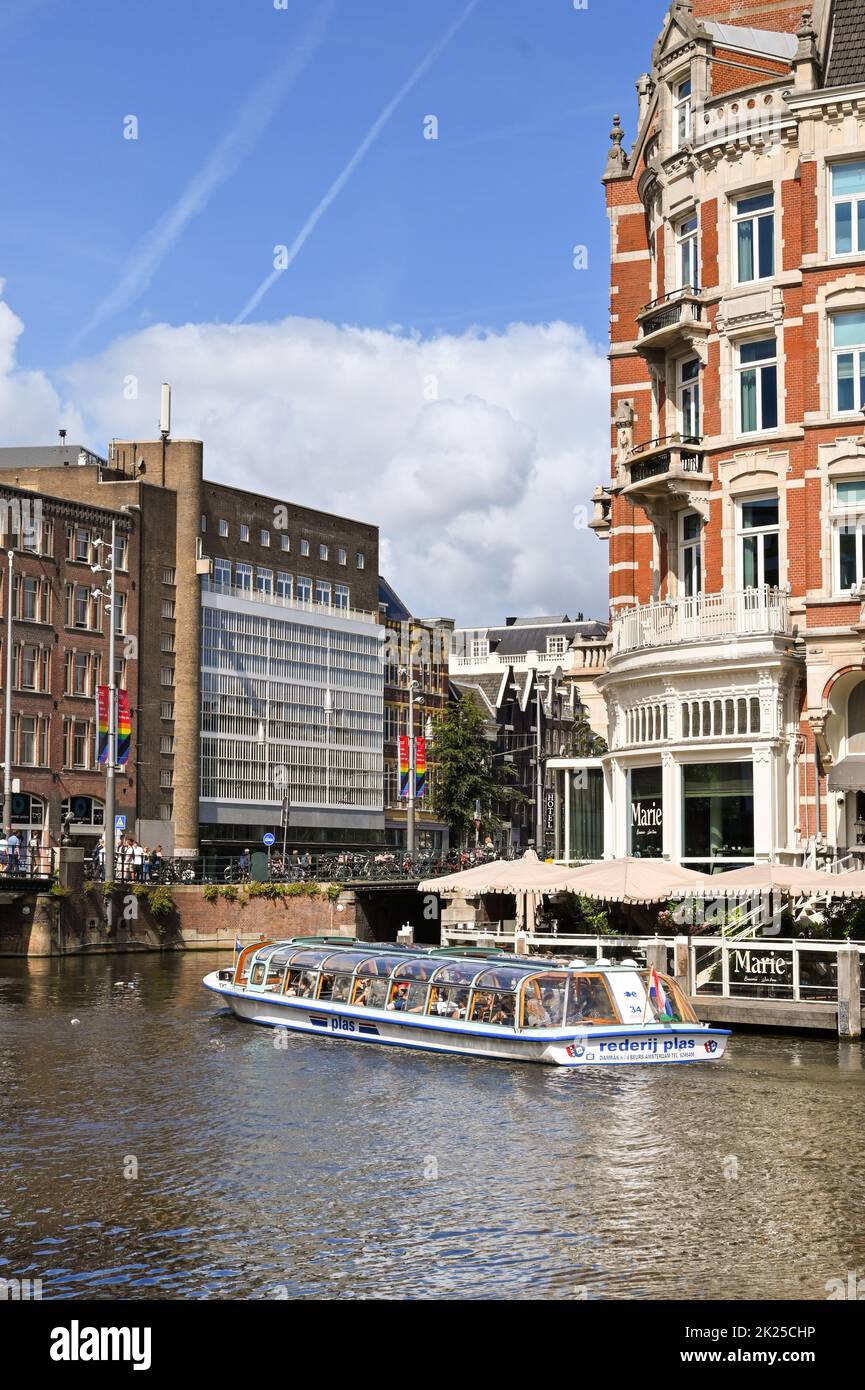 Amsterdam, Netherlands - August 2022: Glass topped tourist sightseeing canal boat cruising on one of the city's centre Stock Photo