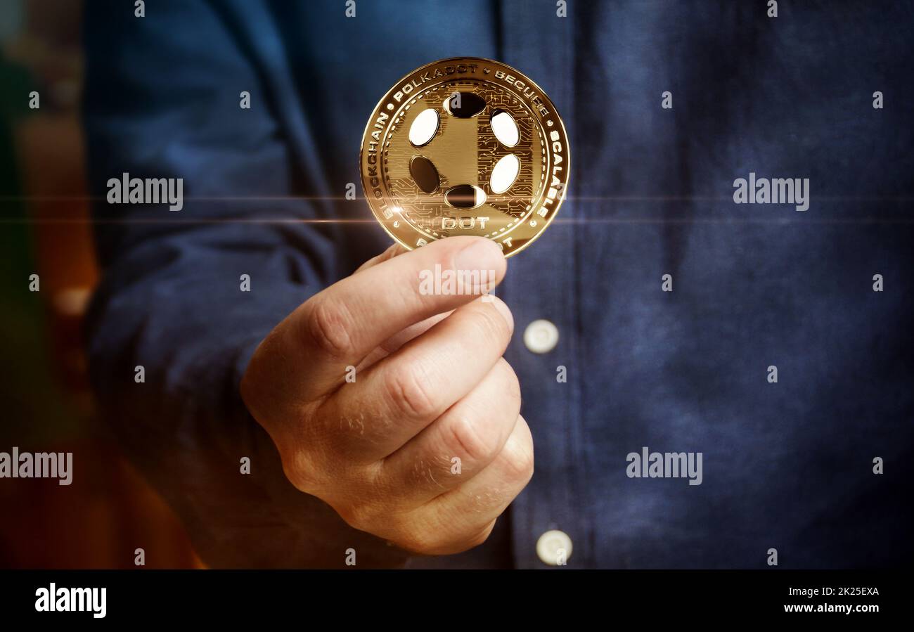 Polkadot DOT cryptocurrency golden coin in hand abstract concept Stock Photo
