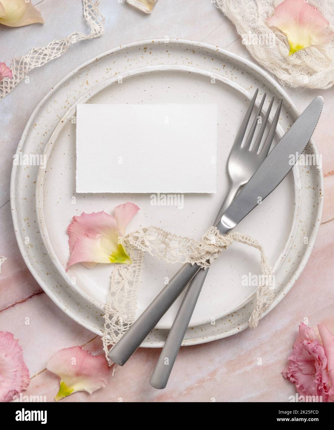 Wedding place card laying on a ceramic plate on a marble table Stock Photo