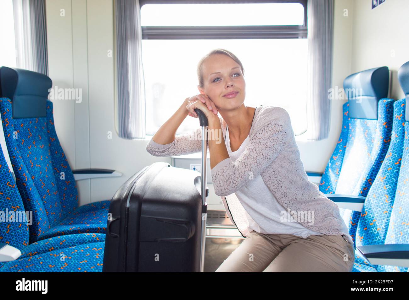 Pretty young woman boarding a train/having arrived to her destination