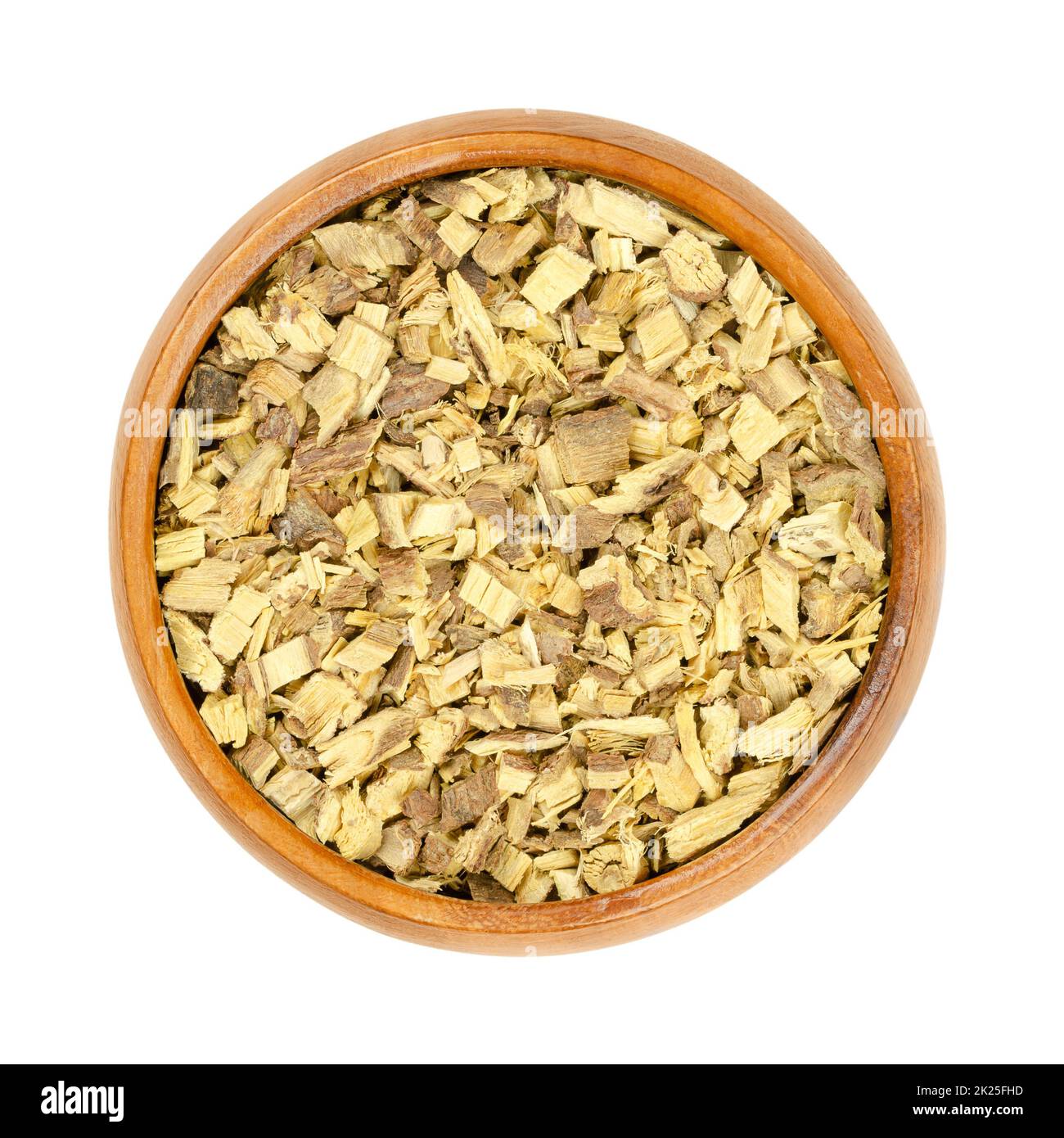 Liquorice root chips, dried cut root of licorice, in wooden bowl Stock Photo