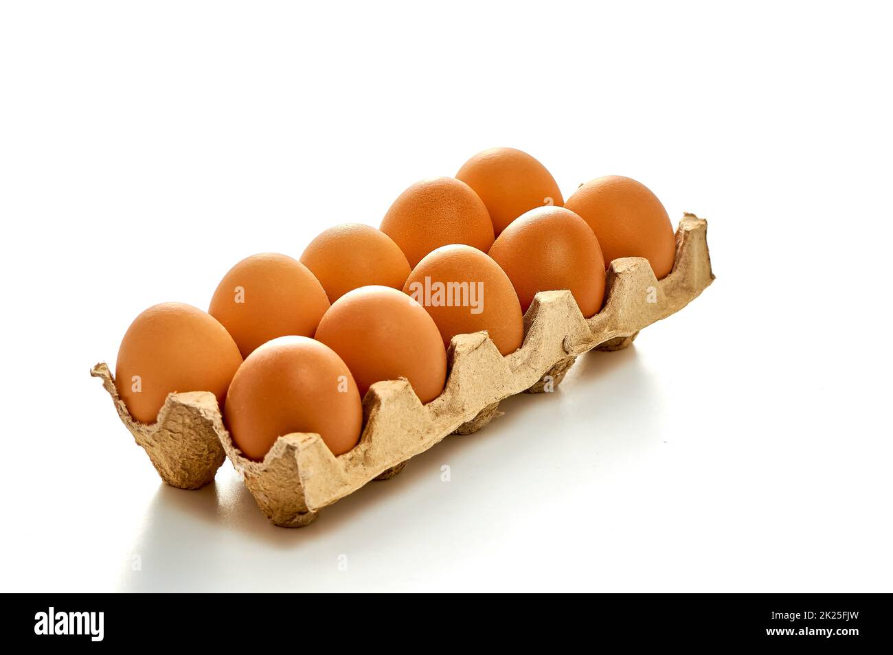 A dozen eggs on a cardboard stand on a white isolated background Stock