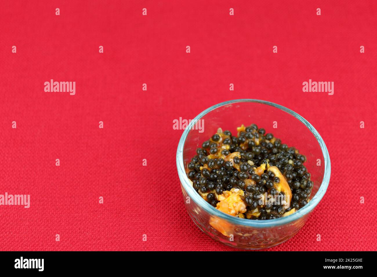 Small Clear Glass Bowl of Fresh Papaya Seeds with Some Pulp Stock Photo