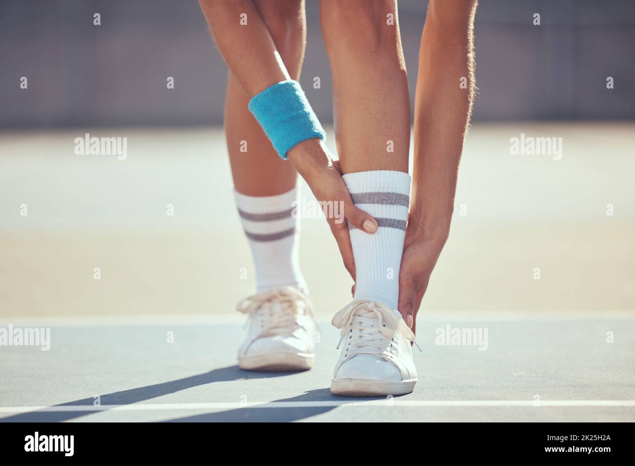 Tennis athlete with ankle injury, pain and hurt on a court after training, workout or practice outdoor. Professional sport person with accident after Stock Photo