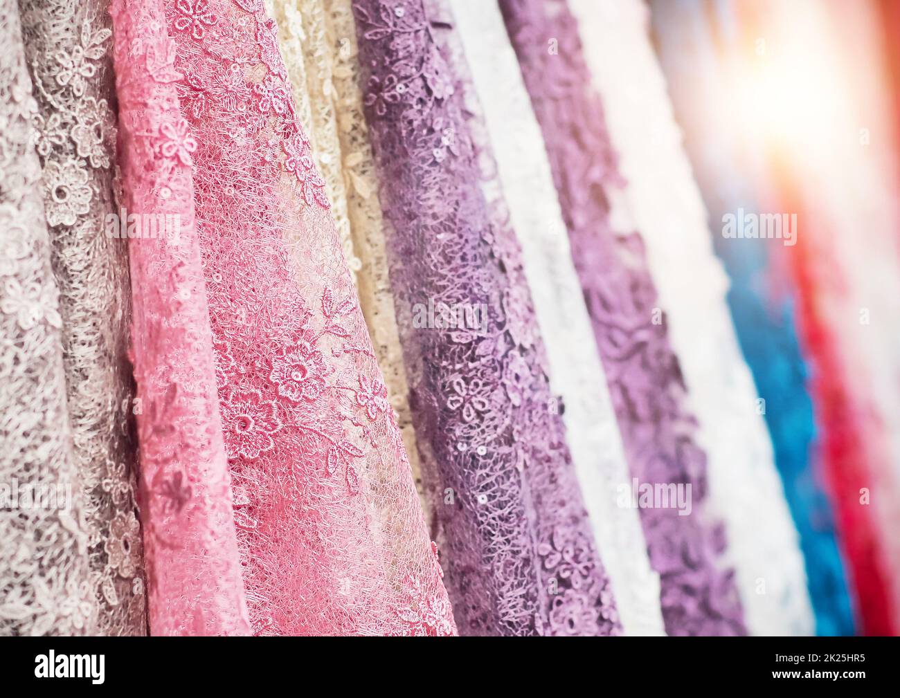 colorful fabric lace fabric rolls in textile shop industry. Rolls of bright colored fabric Stock Photo