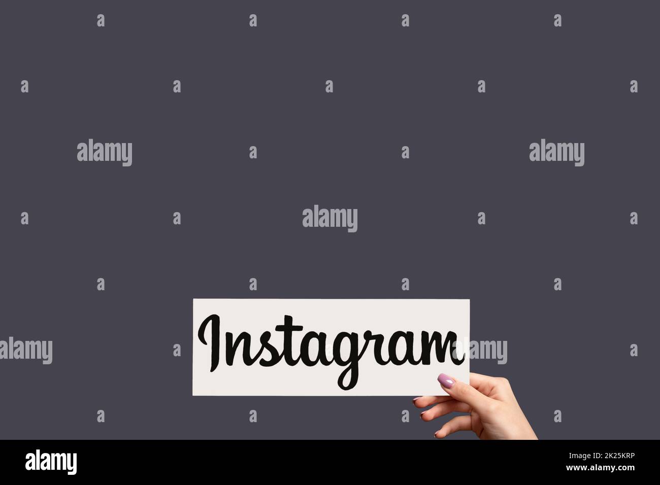 Kharkiv, Ukraine - June 05, 2020: Instagram logo. Digital marketing. Social media. Woman hand showing application icon isolated on purple copy space b Stock Photo